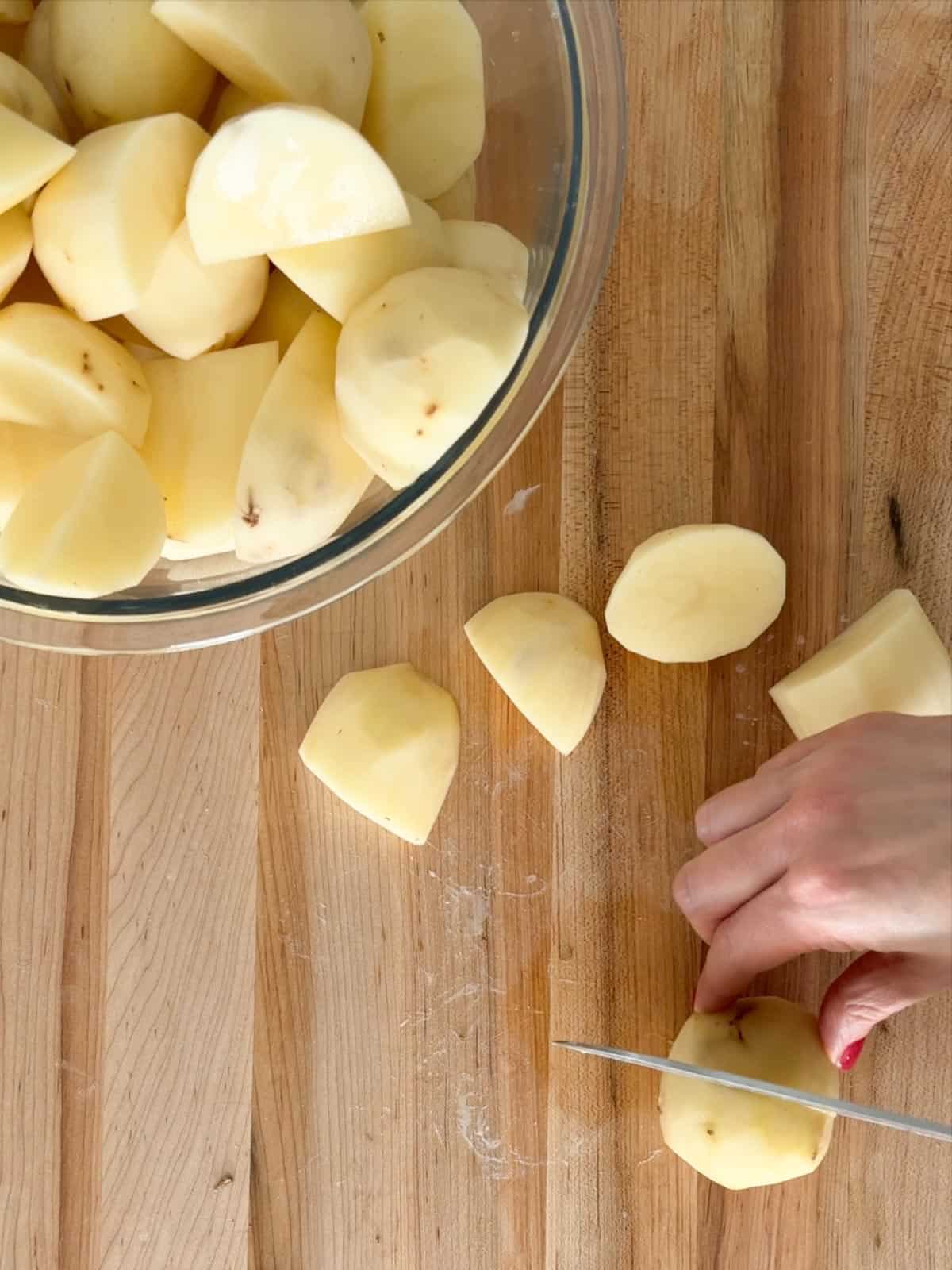 Peeled potatoes are chopped into even pieces.