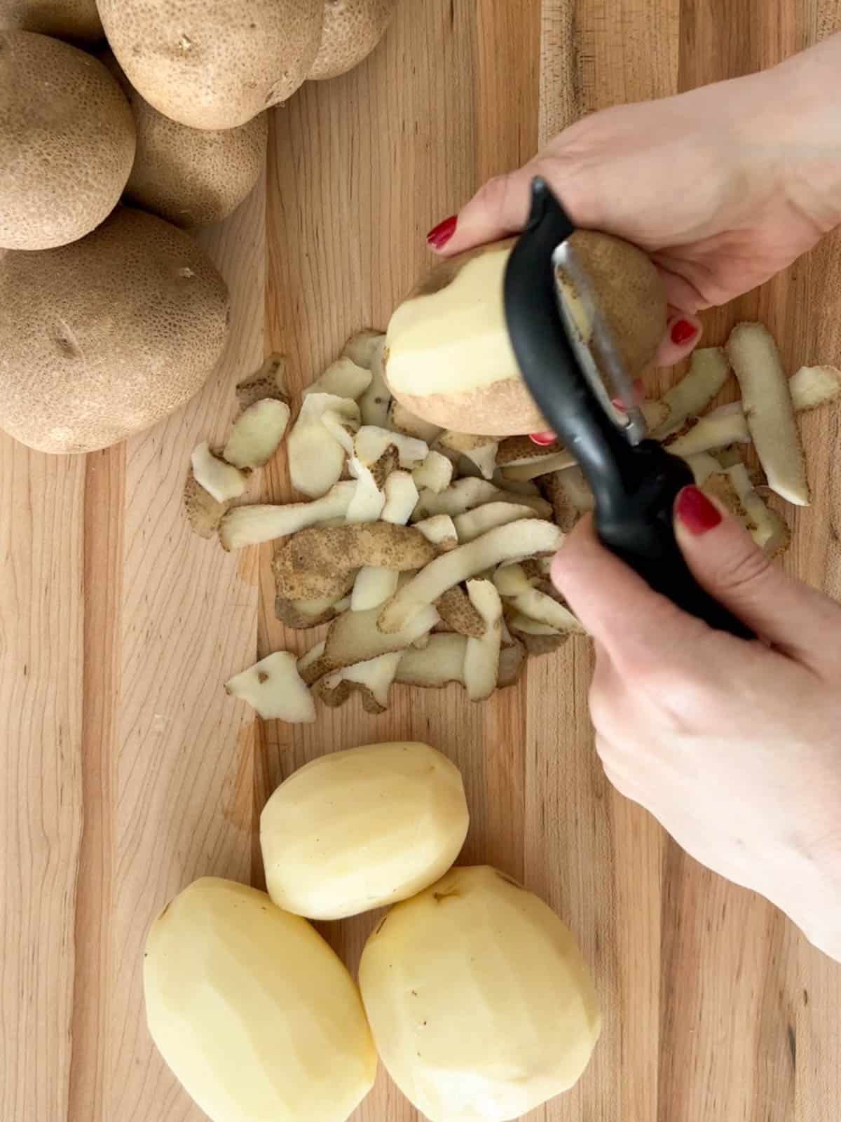 A potato is peeled with a potato peeler.