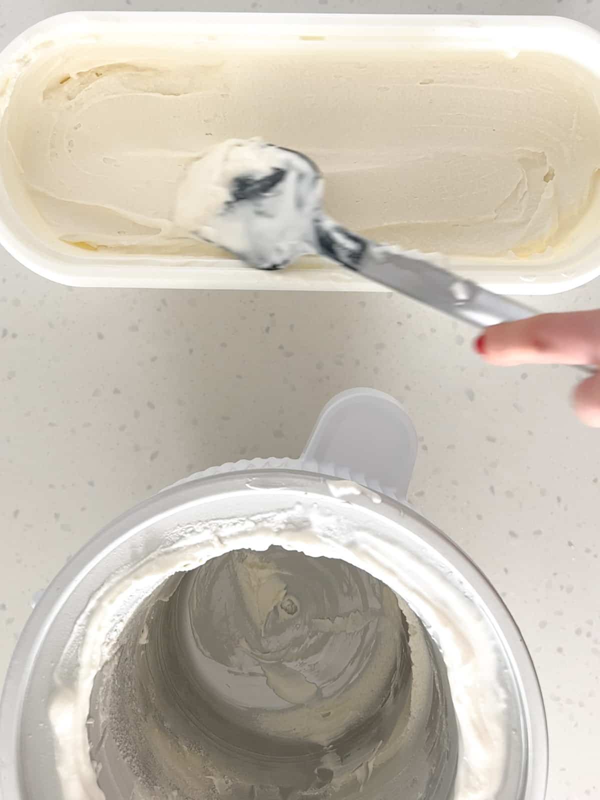 A spatula smooths the top of vanilla ice cream in a freezer safe container.