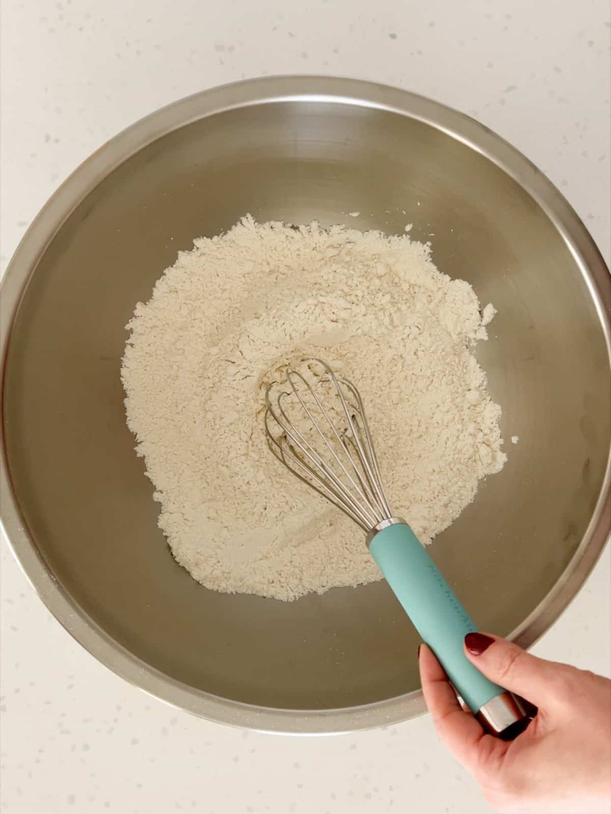 Flour, salt, and sugar whisked together in a bowl.