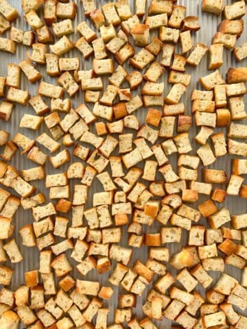 Toasted bread cubes on a baking sheet.