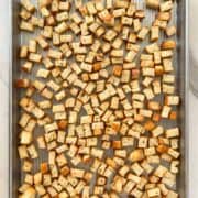 Toasted bread cubes on a baking sheet.
