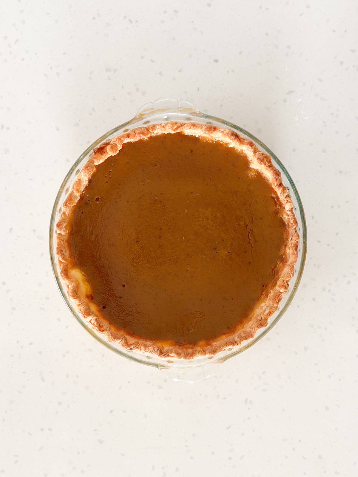 A pumpkin pie is baked until the center is almost set.