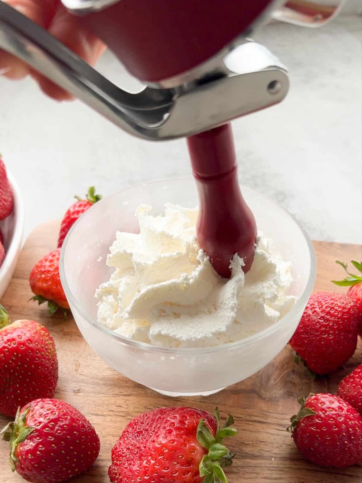 Whipped cream is dispensed in a bowl.
