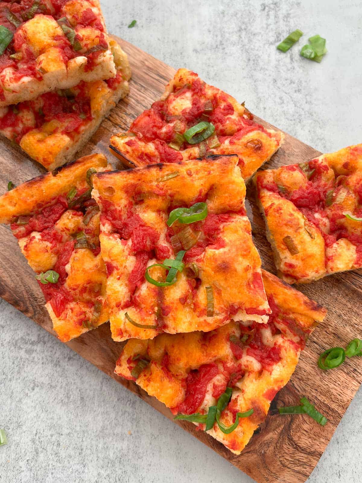 Pieces of Ligurian focaccia on a wood tray.