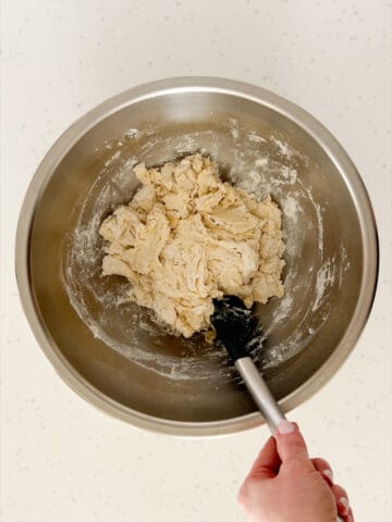 The dry ingredients, yeast mixture, and olive oil are mixed into a shaggy dough.