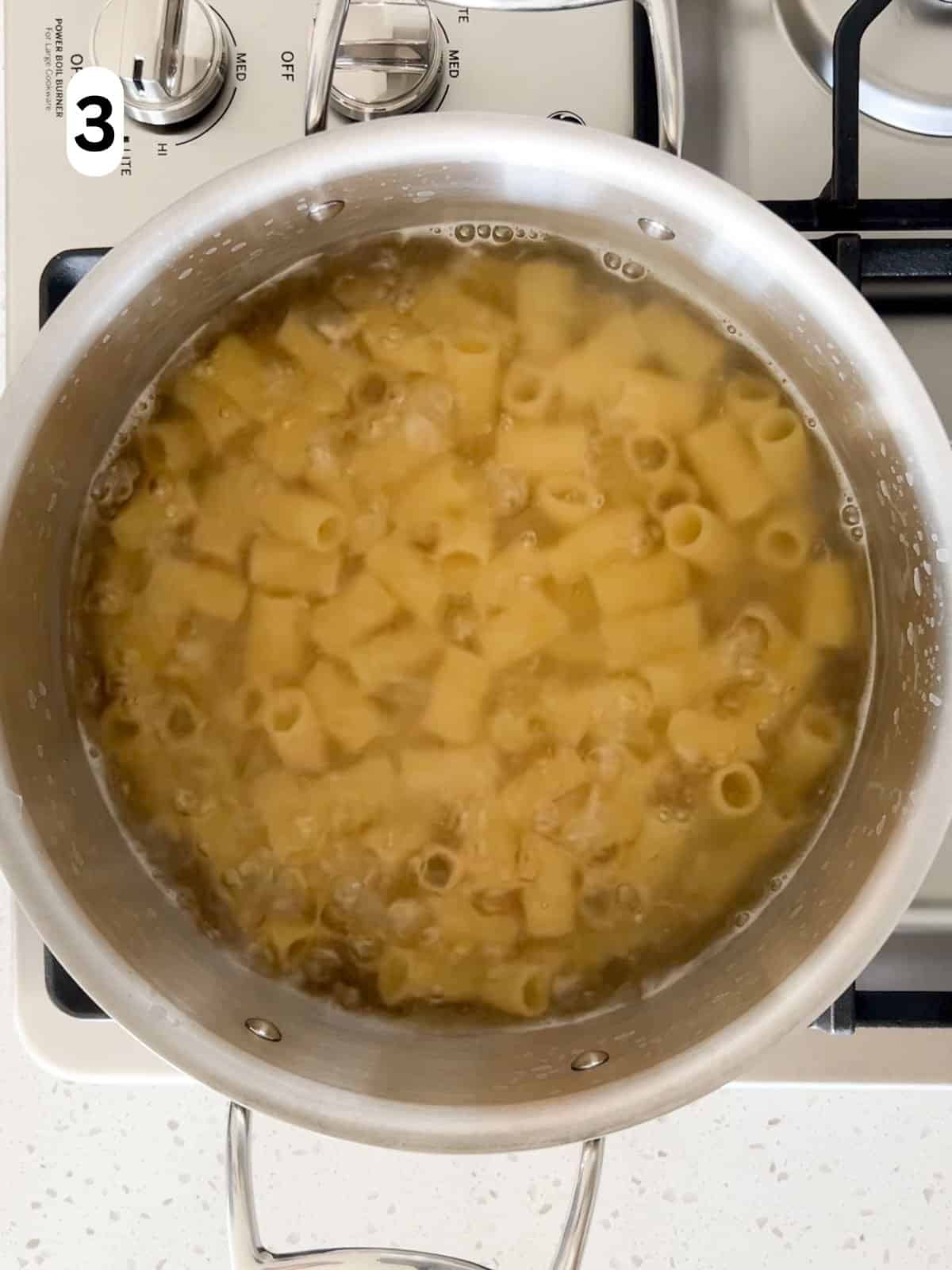 Rigatoni is boiled in a large pot.