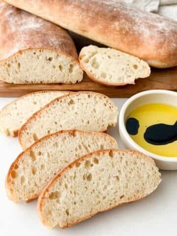 Slices of Italian baguette (stirato) with olive oil and balsamic vinegar to the side.