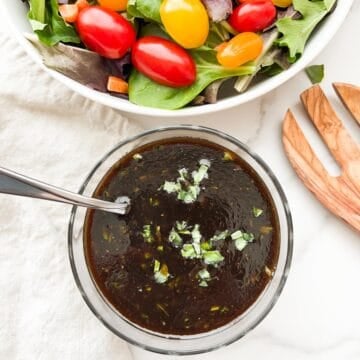 Basil balsamic vinaigrette in a bowl with salad to the side.