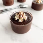 Chocolate budino garnished with whipped cream and chocolate shavings.