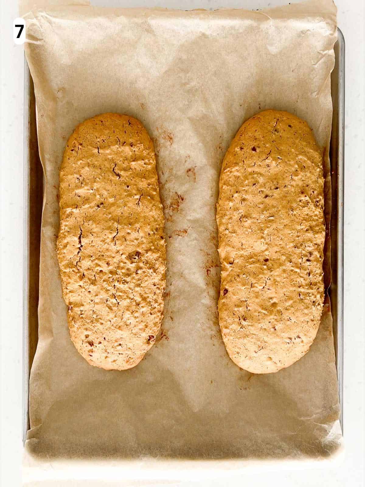 The biscotti logs are baked until lightly golden with small cracks on the top.