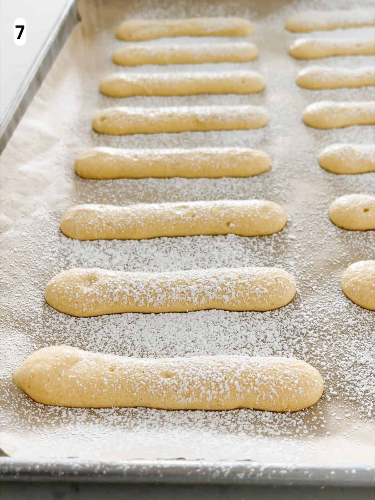 Powdered sugar is dusted on the savoiardi before baking.