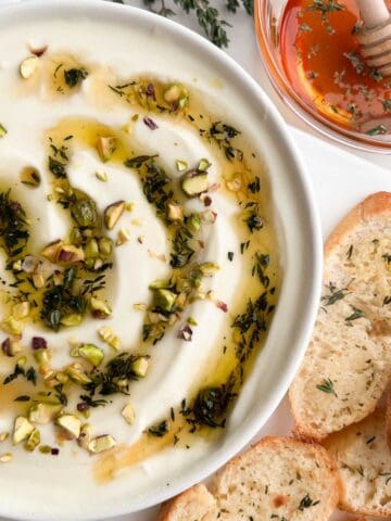 A bowl of whipped ricotta dip served with toasted bread.