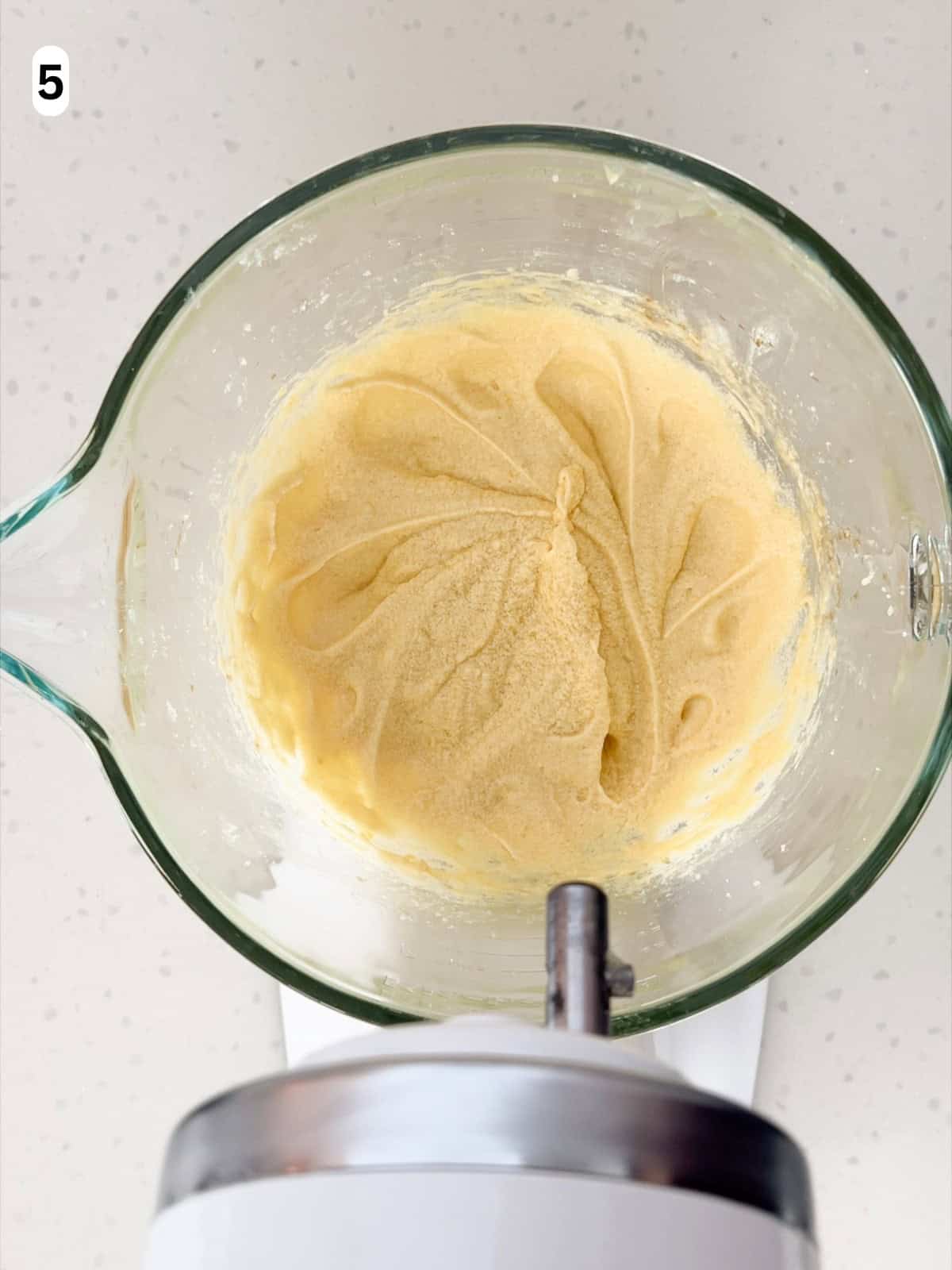 Eggs, vanilla extract, and almond extract are mixed into the dough until combined.