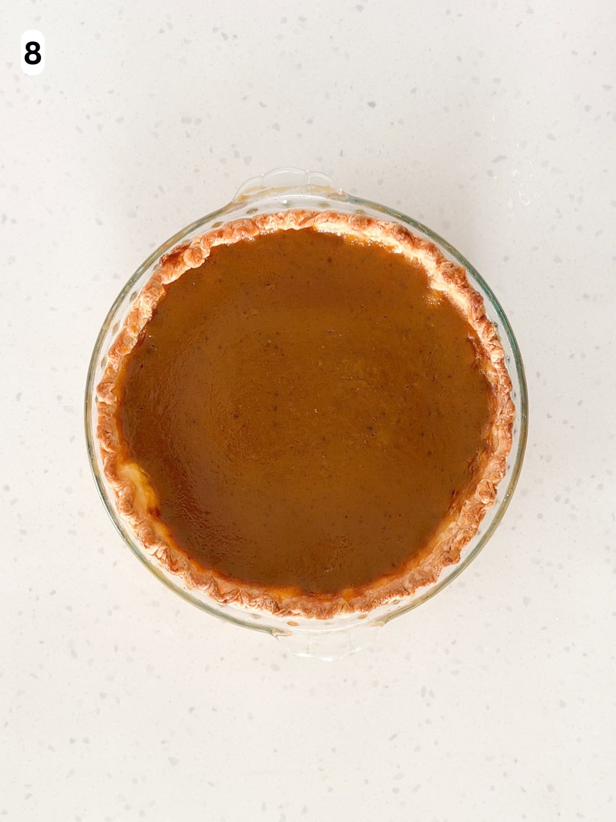 A pumpkin pie is baked until the center is almost set.