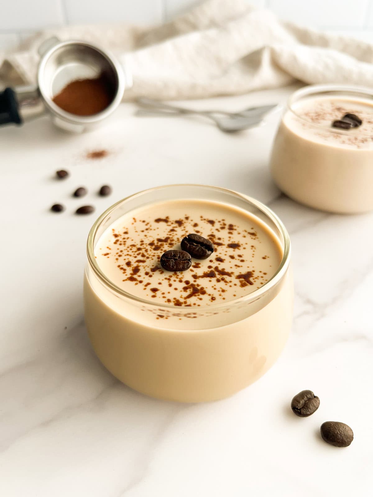 Coffee panna cotta in a serving glass with spoons to the side.