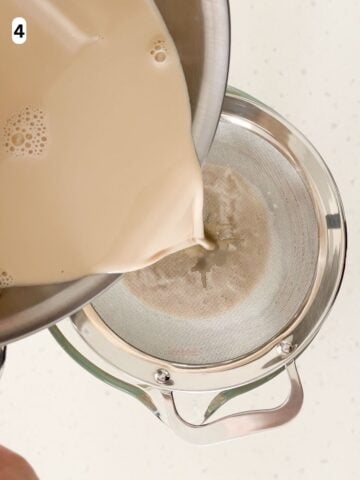 The panna cotta mixture is poured through a fine mesh strainer into a bowl.