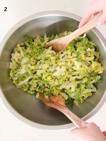 The lettuce is tossed in half of the vinaigrette.