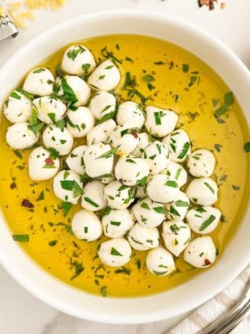 A bowl of marinated mozzarella balls.