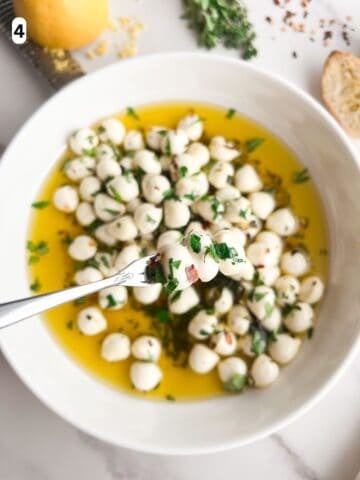 Marinated mozzarella balls on a serving fork.