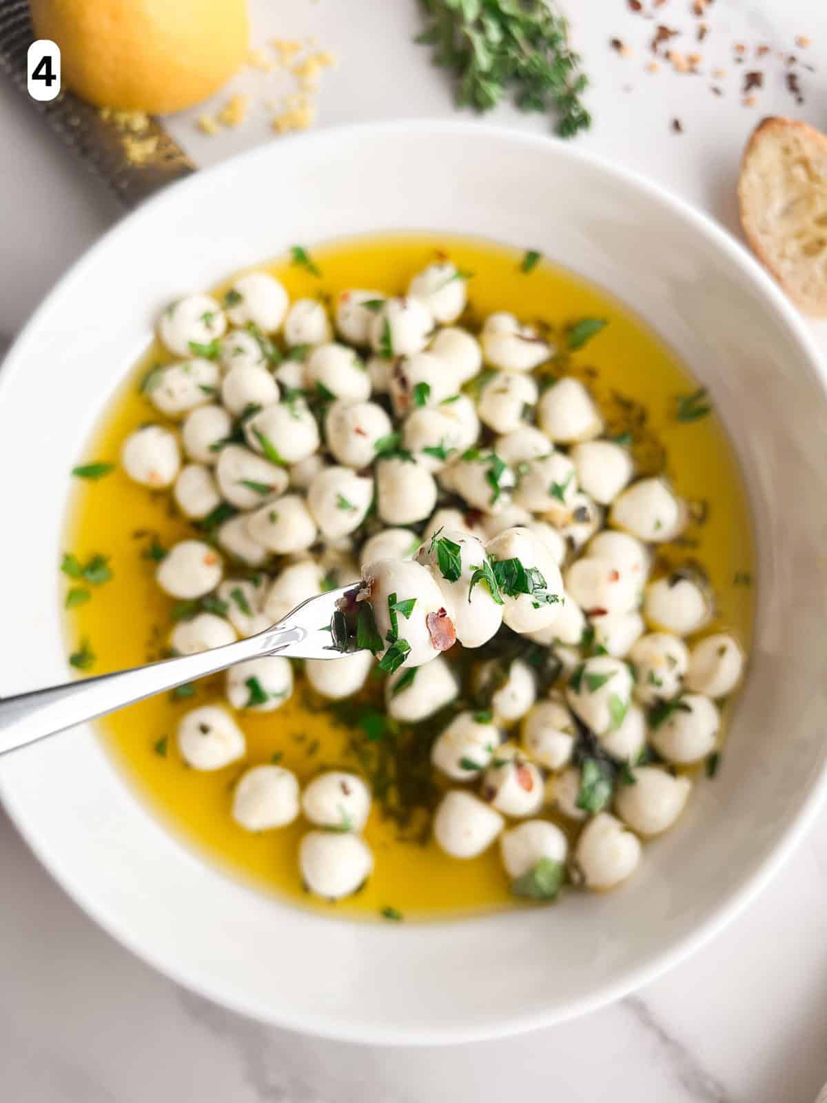 Marinated mozzarella balls on a serving fork.