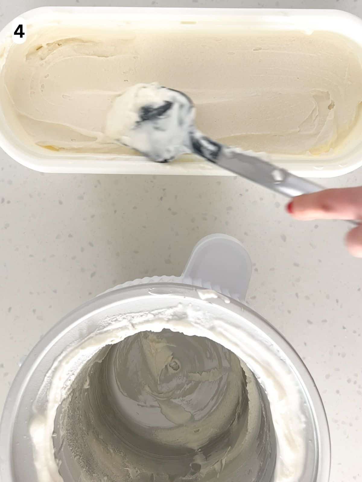 A spatula smooths the top of vanilla ice cream in a freezer-safe container.