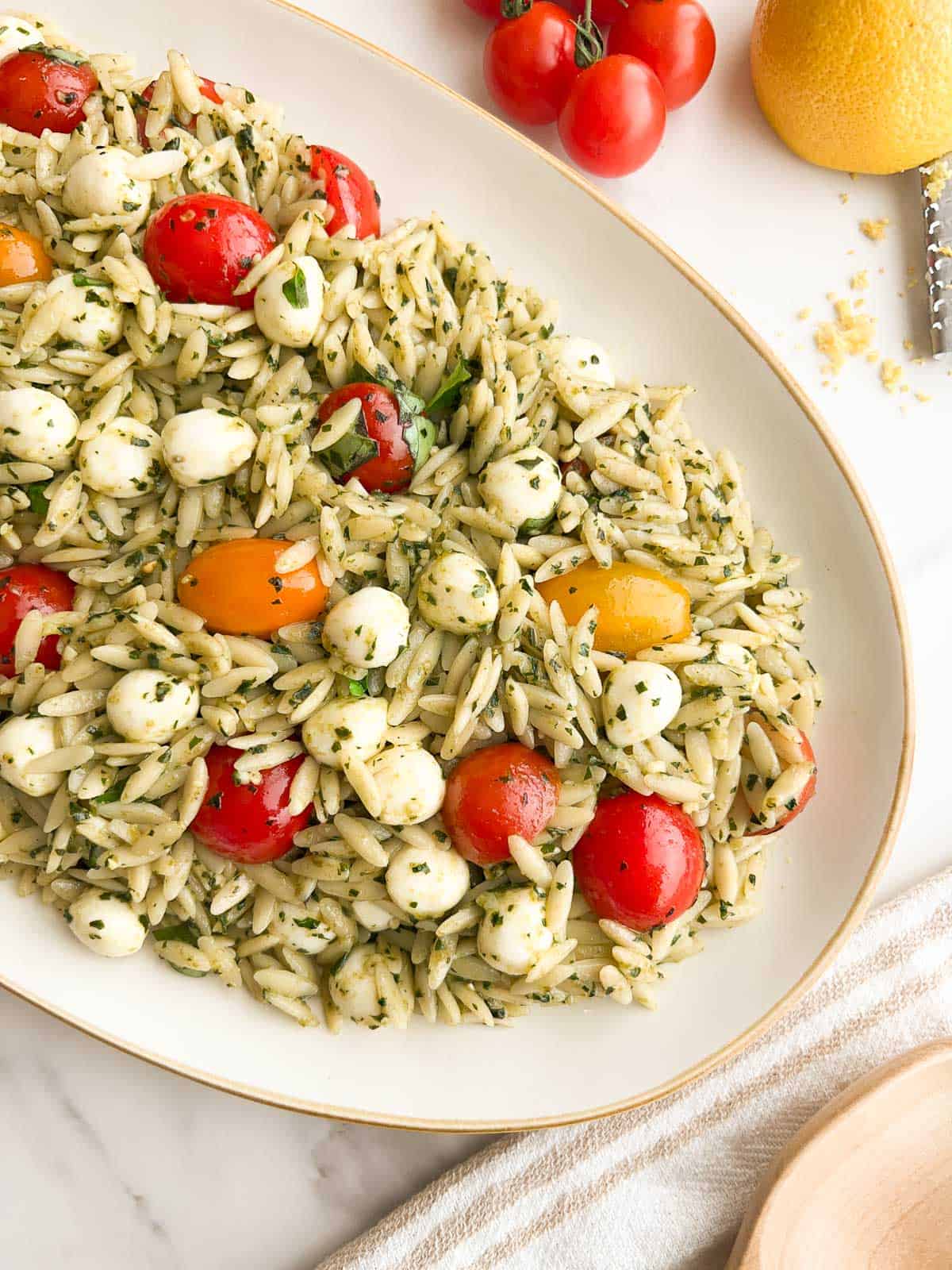 Orzo pesto pasta salad on a serving platter.