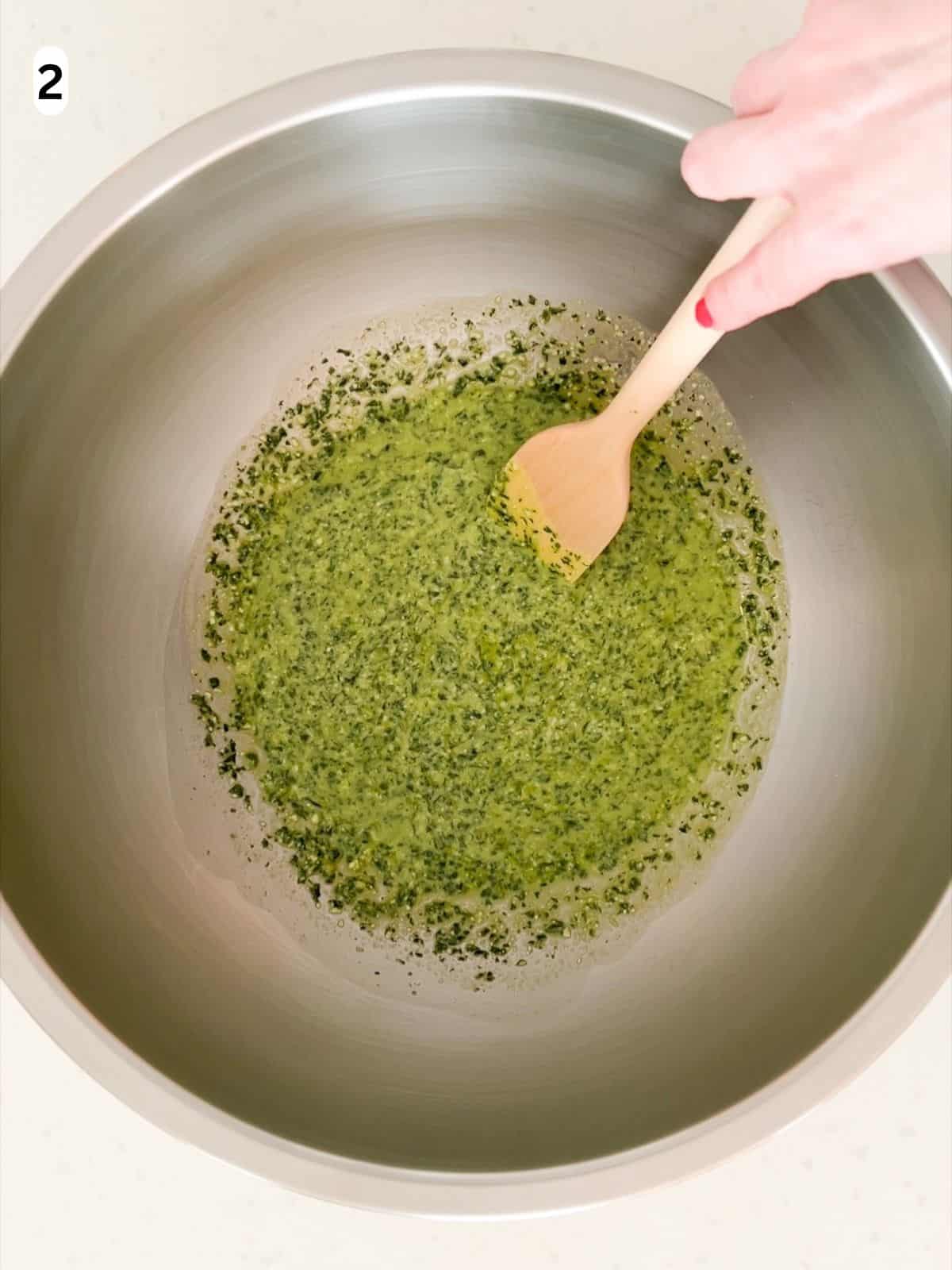 Pesto is mixed with pasta water until combined.