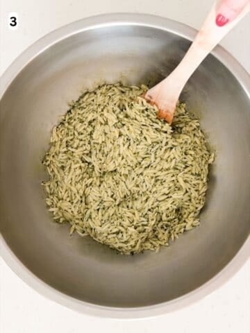 Orzo, pesto, lemon zest, and Parmigiano Reggiano are tossed until combined.
