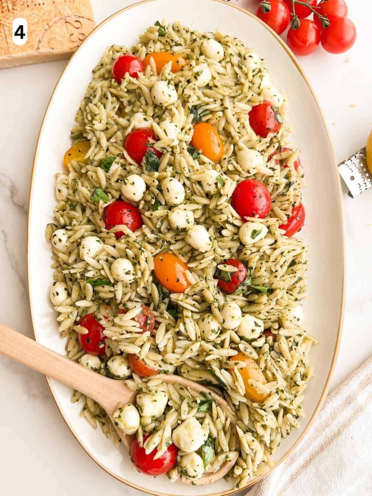 Orzo pesto pasta salad on a serving platter.